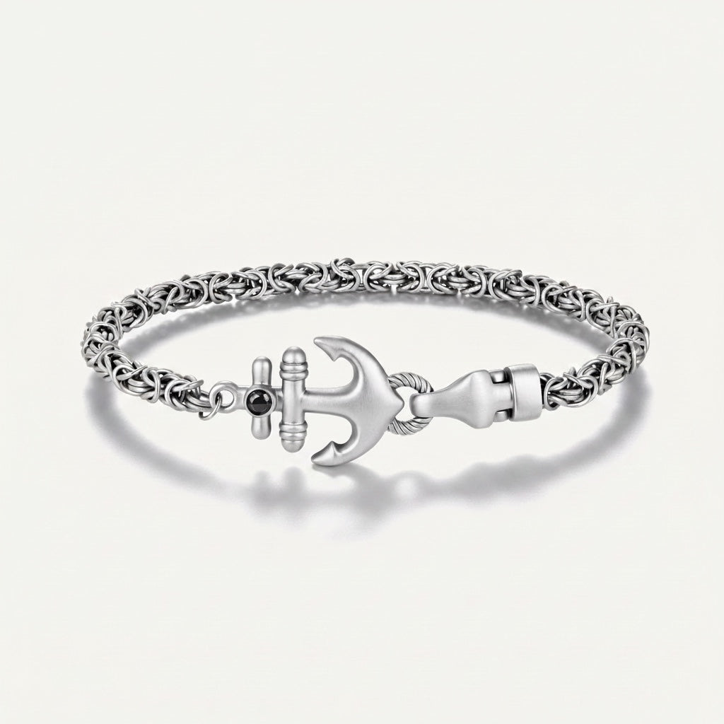 Silver bracelet with anchor charm on a light gray background