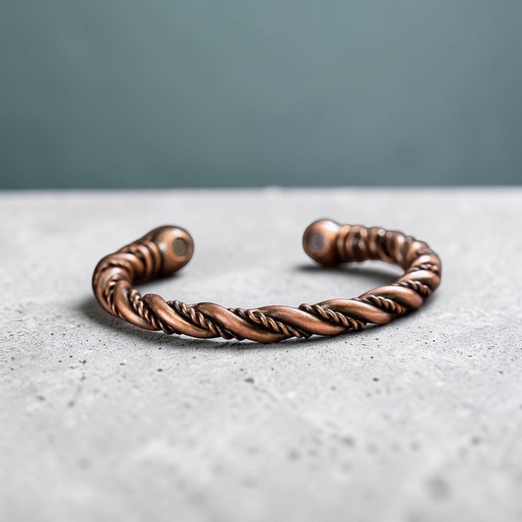 Bronze braided bracelet on a gray surface with a gray background