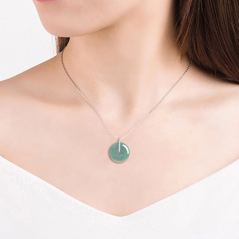 Minimalist lifestyle shot of a model wearing the BoxUnboxed natural jadeite jade pendant necklace on a silver chain.
