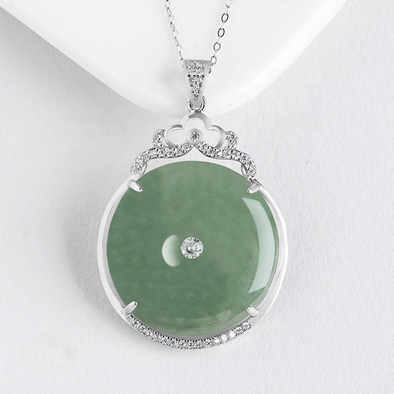 Close-up shot of the BoxUnboxed ornate natural green jadeite jade peace buckle pendant with an intricate S925 sterling silver pave frame and center stone.