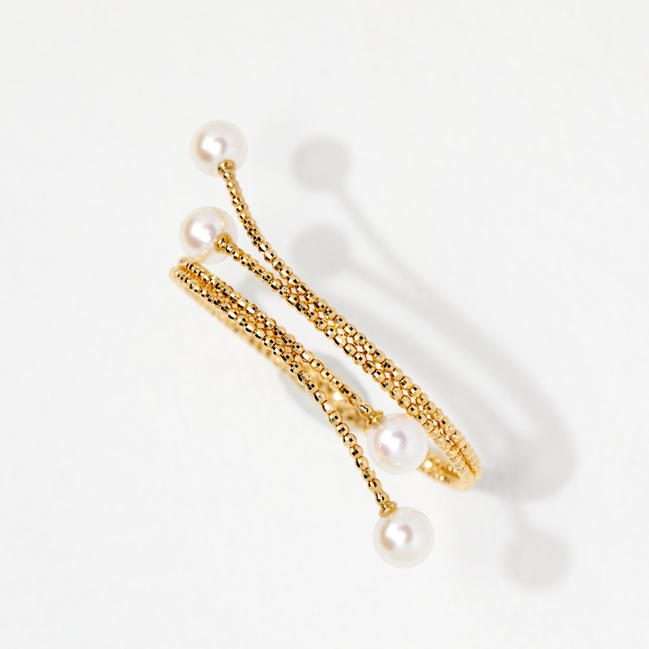 BoxUnboxed 18K yellow gold multi-coil spiral bangle with Akoya pearls and faceted beads.