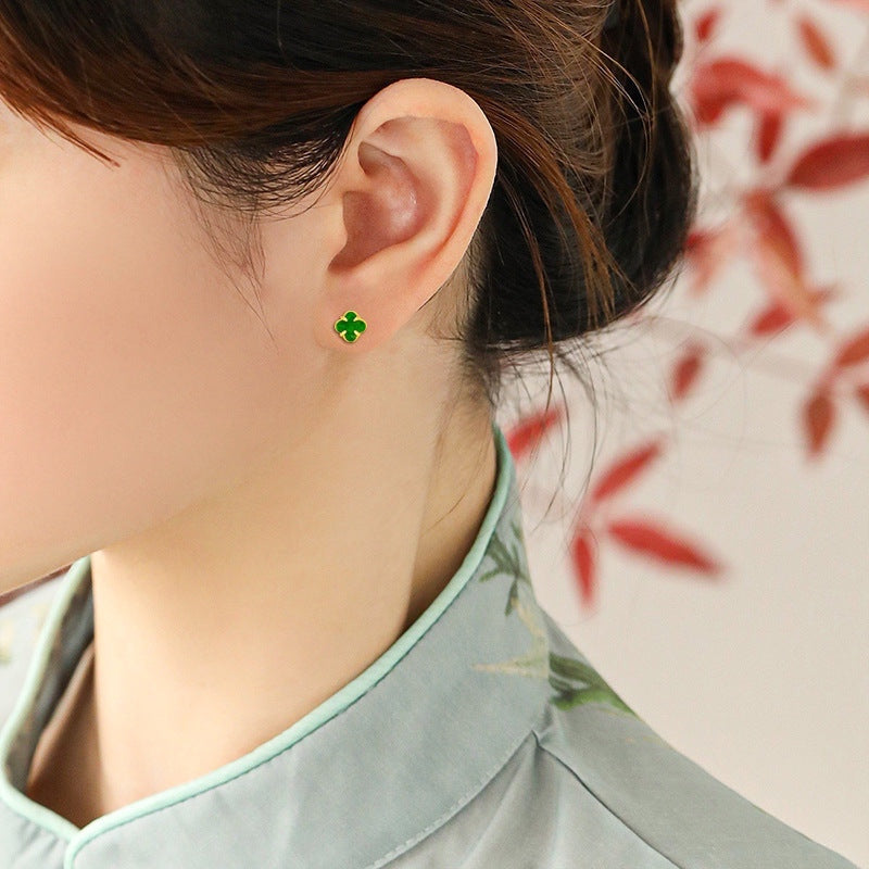 BoxUnboxed gold vermeil stud earrings featuring hand-carved green Myanmar jadeite clover stones worn on a model.