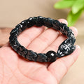 BoxUnboxed hand-carved jadeite dragon bones bracelet in dark teal and charcoal hues, featuring scale links and a dragon head clasp.